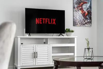 a television on a white entertainment center in a living room at 4 Bedroom Town Home with Garage Parking, Fast WiFi, Smart TV with Netflix, Fully Equipped Kitchen, Sleeps 10, Ideal for Families in Airdrie
