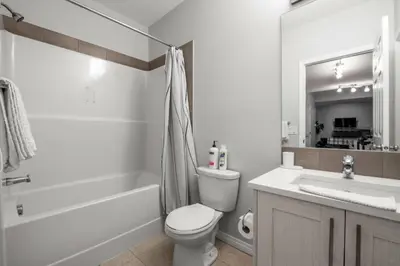 a bathroom with a toilet and a tub and a sink at Top Rated Luxury House with Central AC, Double Garage Parking, 2 Kitchens, 5 Bedrooms & More! in Balzac
