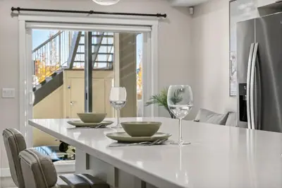 a kitchen with a table with two wine glasses at Private Suite with Queen Bed, Queen Sofa Bed, Netflix, Patio, Sleeps 4 in Calgary
