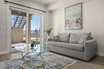 a living room with a couch and a glass table at Private Suite with Queen Bed, Queen Sofa Bed, Netflix, Patio, Sleeps 4 in Calgary