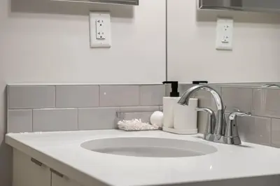 a white kitchen counter with a sink and a sink at Private Suite with Queen Bed, Queen Sofa Bed, Netflix, Patio, Sleeps 4 in Calgary