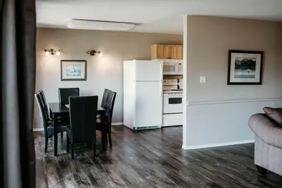 a dining room with a table and a white refrigerator at Page's Inn on Silva Bay in Gabriola