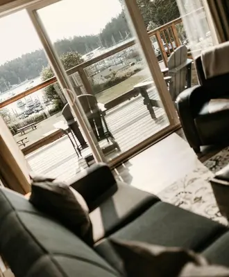 a living room with a couch and a large window at Page's Inn on Silva Bay in Gabriola