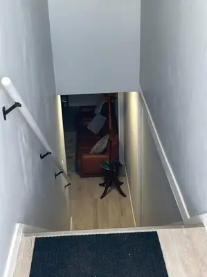 a hallway with a stairway with a couch in a room at Forth Street 2Bedroom Suite in Calgary