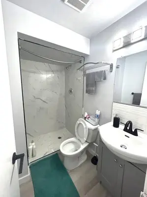 a bathroom with a shower and a toilet and a sink at Forth Street 2Bedroom Suite in Calgary