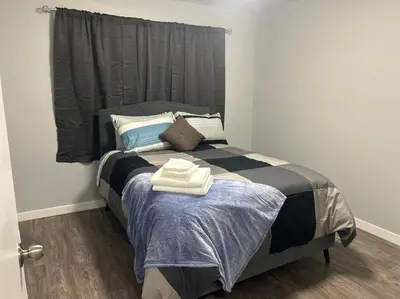 a bedroom with a bed with two towels on it at Cute Highland Park Upper B Unit in Calgary