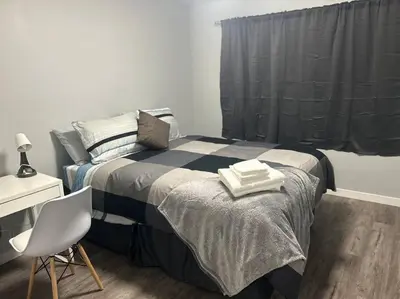 a bedroom with a bed with two towels on it at Cute Highland Park Upper B Unit in Calgary
