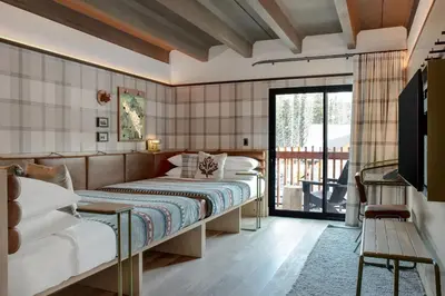 a bedroom with a bed and a balcony at Moxy Banff in Banff