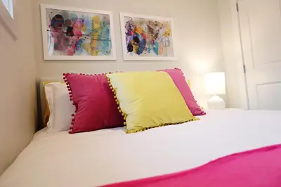a white bed with three pillows on top of it at Downtown 3 Queen Beds, AC, Double Garage, Disney in Edmonton