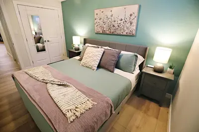 a bedroom with a large bed with a green bedspread at Downtown Suite King Beds,Long Stays,Disney+ in Edmonton