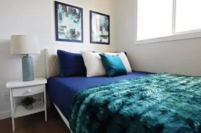a bedroom with a bed with a blue blanket at Downtown 5 Bedroom, AC, Rogers, Commonwealth, EXPO in Edmonton