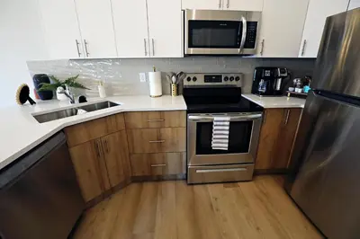 a kitchen with stainless steel appliances and wooden cabinets at Downtown 5 Bedroom, AC, Rogers, Commonwealth, EXPO in Edmonton