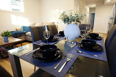 a table with plates and wine glasses on it at Central Suite King Beds,Long Stays,Disney+ in Edmonton