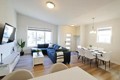 a living room with a blue couch and a table at Central 5 Bedroom, AC, Rogers, Commonwealth, EXPO in Edmonton