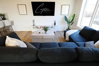a living room with two blue couches and a table at Central 5 Bedroom, AC, Rogers, Commonwealth, EXPO in Edmonton