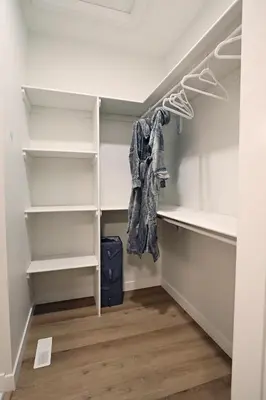 a walk in closet with white shelves at Central 5 Bedroom, AC, Rogers, Commonwealth, EXPO in Edmonton