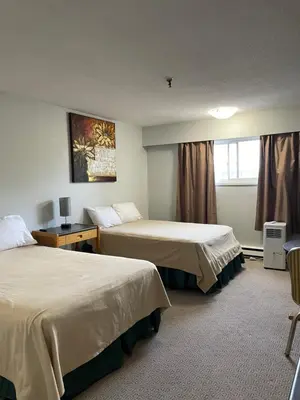 a hotel room with two beds and a window at Nechako Valley Inn in Vanderhoof