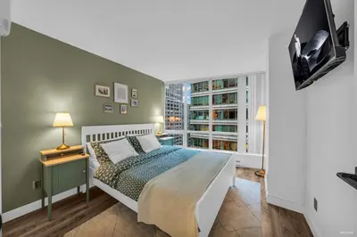 a bedroom with a bed and a window at 1-BR Condo in Downtown Coal Harbour with Parking and City Views in Vancouver