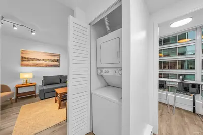 a living room with a couch and a table at 1-BR Condo in Downtown Coal Harbour with Parking and City Views in Vancouver
