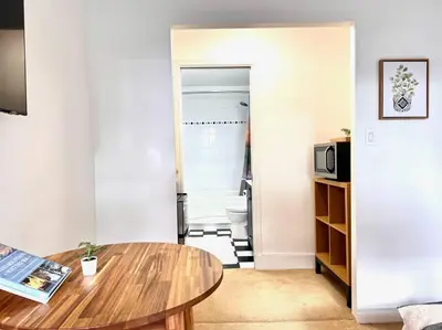 a living room with a table and a microwave at 'Canyon Heights' Retreat (Grouse Mountain) in North Vancouver