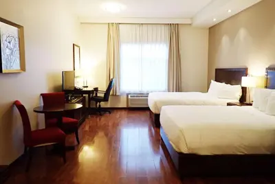 a hotel room with two beds and a desk at Days Inn & Suites by Wyndham Fort Saskatchewan in Fort Saskatchewan