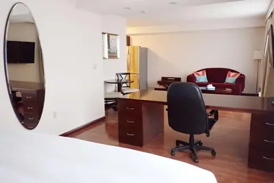 a bedroom with a desk and a chair and a mirror at Days Inn & Suites by Wyndham Fort Saskatchewan in Fort Saskatchewan