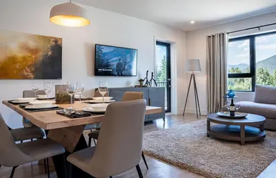 a dining room and living room with a table and chairs at The Stoke Stopover - Revelstoke Condo with Hot Tub in Revelstoke