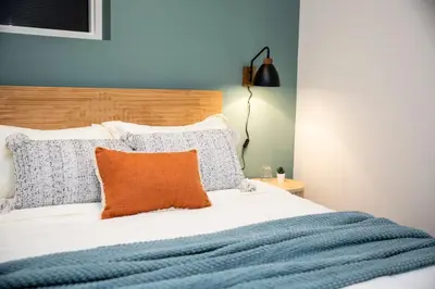 a bedroom with a bed with an orange pillow at The Stellar Condo - Cozy 2 Bedroom with Hot Tub in Revelstoke
