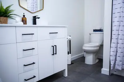 a white bathroom with a sink and a toilet at The Stellar Condo - Cozy 2 Bedroom with Hot Tub in Revelstoke