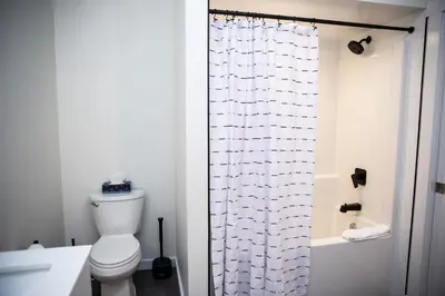 a bathroom with a toilet and a shower curtain at The Stellar Condo - Cozy 2 Bedroom with Hot Tub in Revelstoke