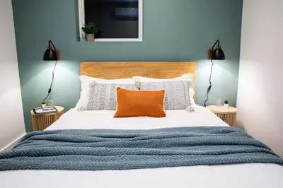 a bedroom with a large bed with an orange pillow at The Stellar Condo - Cozy 2 Bedroom with Hot Tub in Revelstoke