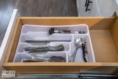 a tray with utensils in a wooden drawer at Boho Suite - Long Stays - King Bed - Fireplace & WiFi in Edmonton