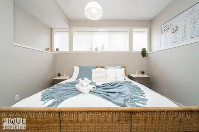 a bedroom with a large bed with a teddy bear on it at Boho Suite - Long Stays - King Bed - Fireplace & WiFi in Edmonton