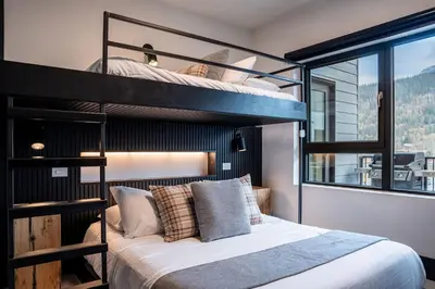 a bedroom with two bunk beds and a window at Altitude Adjustment by Revelstoke Vacations in Revelstoke
