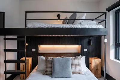 two bunk beds in a room with a bed at Altitude Adjustment by Revelstoke Vacations in Revelstoke
