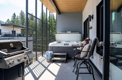 a screened in porch with a grill and a stove at Altitude Adjustment by Revelstoke Vacations in Revelstoke