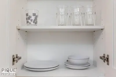 a shelf with plates and glasses on it at BoHo Chic Suite - Long Stays - Fireplace - Garage in Edmonton