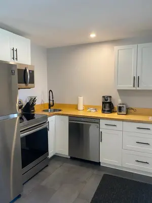 a kitchen with white cabinets and stainless steel appliances at River's Edge Retreat in Clearwater