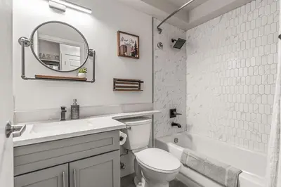 a bathroom with a toilet and a sink and a mirror at W118 NEW! Central Canmore- Light Industrial Hotel Room in Canmore