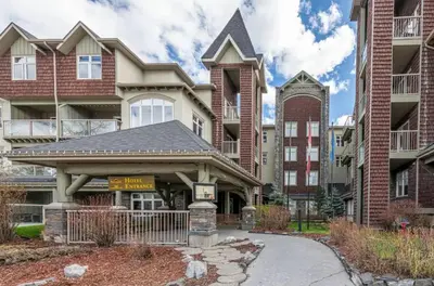 a house with a gate in front of a building at W118 NEW! Central Canmore- Light Industrial Hotel Room in Canmore