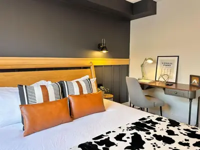 a bedroom with a bed with black and white pillows at W118 NEW! Central Canmore- Light Industrial Hotel Room in Canmore