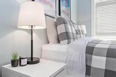 a bedroom with a bed and a table with a lamp at 2BR in Granite Court, Village Location, Gas Fireplace, Mudroom, Secure Parking in Whistler