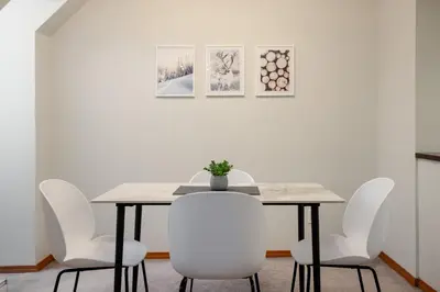 a dining room table with white chairs and a white wall at 1BR in Marquise, Near Ski Hill, Fireplace, Heated Pool, Hot Tub, Sauna, Gym, Free Shuttle in Whistler