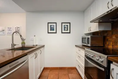 a kitchen with a sink and a microwave at 1BR in Marquise, Near Ski Hill, Fireplace, Heated Pool, Hot Tub, Sauna, Gym, Free Shuttle in Whistler