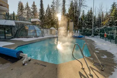 a book with a hot spring next to a swimming pool at 1BR in Marquise, Near Ski Hill, Fireplace, Heated Pool, Hot Tub, Sauna, Gym, Free Shuttle in Whistler