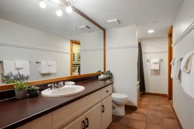 a bathroom with a sink and a toilet and a mirror at 1BR in Marquise, Near Ski Hill, Fireplace, Heated Pool, Hot Tub, Sauna, Gym, Free Shuttle in Whistler
