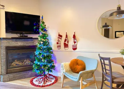 a christmas tree in a living room with a fireplace at G222 Family Fun- MTN View Stay, Water slide, Pool, Hot Tub, Free Parking in Canmore