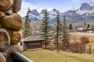 a house with a garage with mountains in the background at G222 Family Fun- MTN View Stay, Water slide, Pool, Hot Tub, Free Parking in Canmore