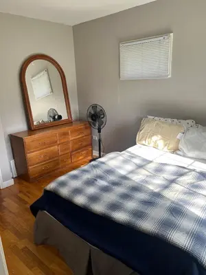 a bedroom with a bed and a dresser and a mirror at Farm House - L&S Farms in Chilliwack