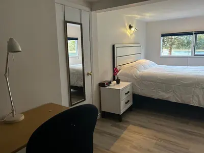 a bedroom with a bed and a desk and a mirror at Waterfront, Mountainview House in Castlegar in Castlegar